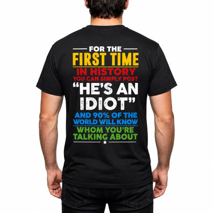 Plain t-shirt with bold typographic text reading "He's an idiot" centered on the chest