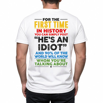 Plain t-shirt with bold typographic text reading "He's an idiot" centered on the chest