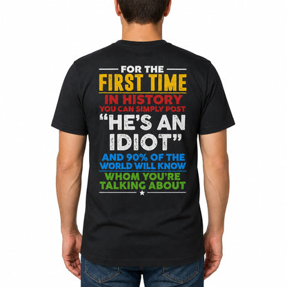 Plain t-shirt with bold typographic text reading "He's an idiot" centered on the chest